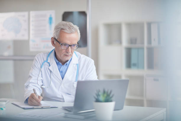 istock Senior doctor working at office 1196710712