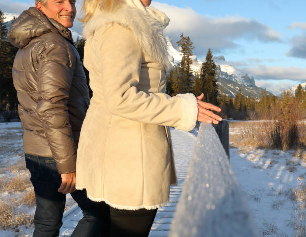 istock Mature couple walk along boardwalk in winter 1196710733