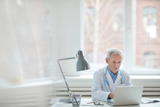 istock Senior medical specialist working on laptop 1196710826