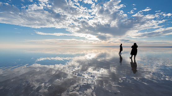 Young couple walking on salt lake at sunset