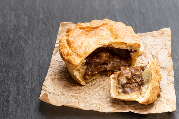 istock Puff pastry steak pie on baking paper on black stone backgroung 1196711846