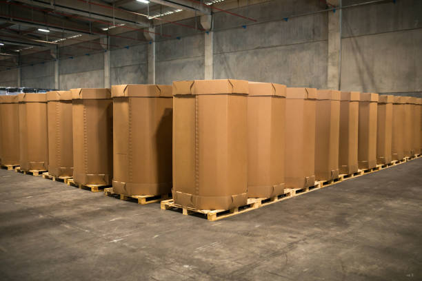 Stack of big, blank and empty cardboard boxes in warehouse, factory or industrial packaging facility. Rows of Craft Cargo Boxes stacked side by side Industrial production in factory concept image big cardboard box stock pictures, royalty-free photos & images