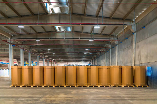 istock Stack of big, blank and empty cardboard boxes in warehouse, factory or industrial packaging facility. Rows of Craft Cargo Boxes stacked side by side 1196712405