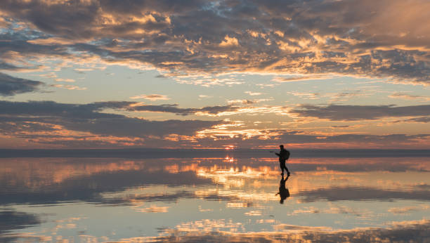 istock Young Traveller Man Flying a Drone in Salt Lake. 1196712487