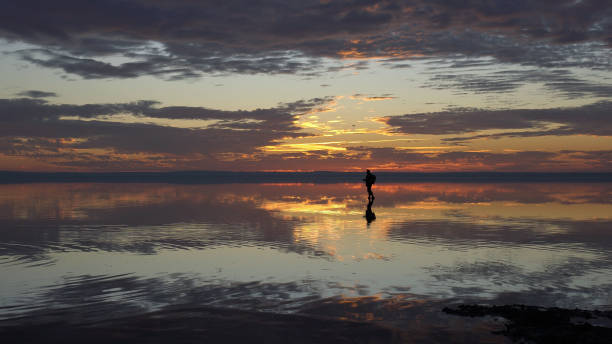 istock Young traveller walking on the salt lake by sunset 1196712641