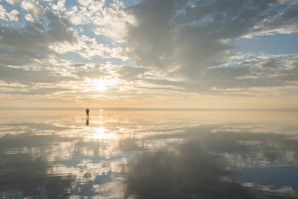 Young traveller walking on the salt lake by sunset