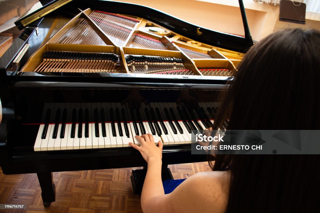 Shot From Behind An Young Woman Playing A Piano In A Studio Photo - Download Image Now - iStock