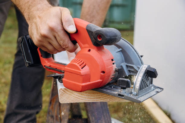 istock Carpenter cutting wooden plank hand held electric saw 1196725403