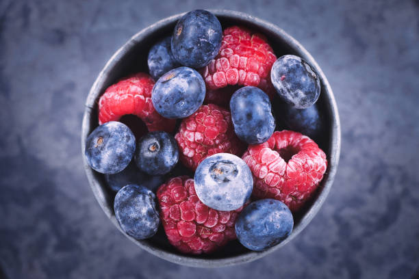 鉄のカップの混合ブルーベリーとラズベリーフルーツのトップビュー - fruit cup ストックフォトと画像
