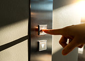 woman's finger presses the Elevator button