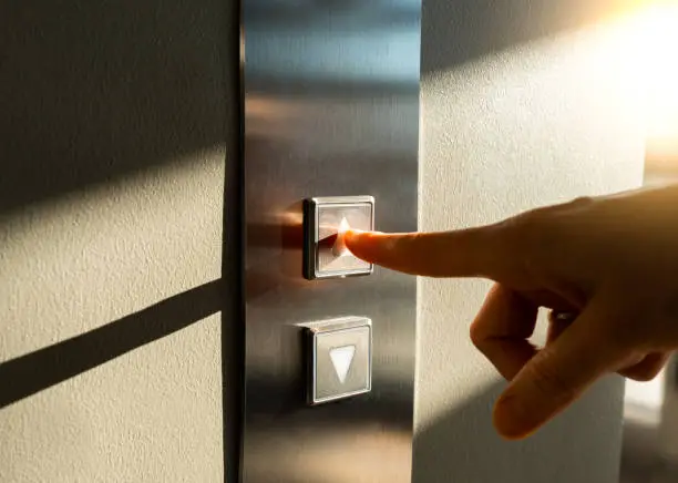 Photo of woman's finger presses the Elevator button