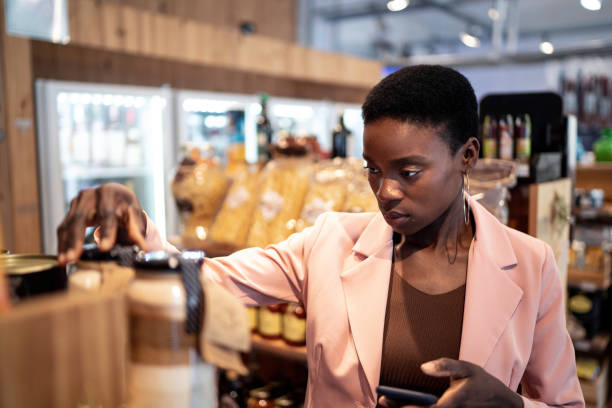istock Businesswoman using smartphone while shopping in a supermarket 1196729500