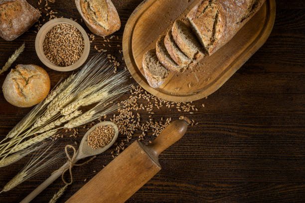 istock Bread, traditional bread and wheat on wooden backround. 1196729509