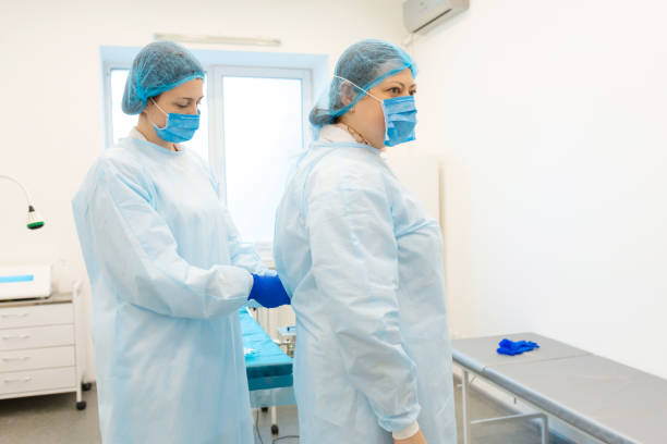 istock A nurse dresses a surgeon in a sterile suit before surgery 1196734032