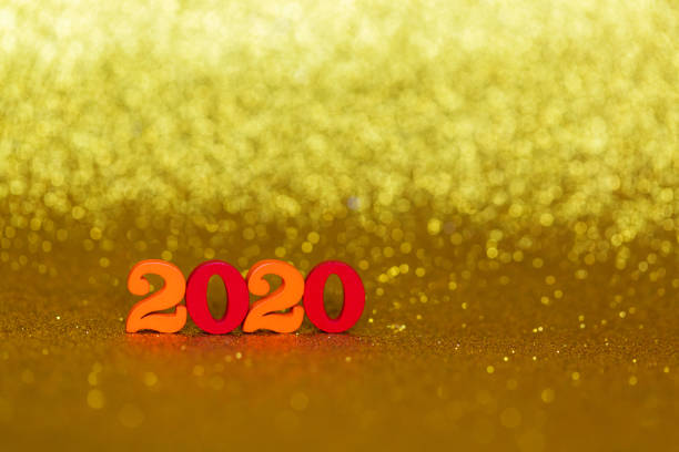istock Wooden numbers 2020 on a golden background 1196739552