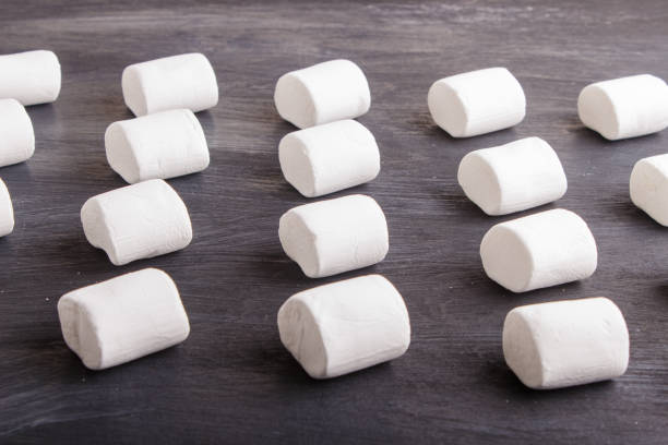 istock set of marshmallows on black  wooden background. top view, flat lay. geometric pattern. 1196740478
