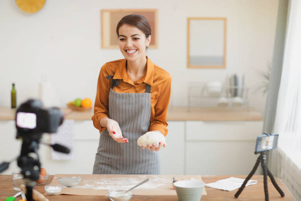 istock Smiling Woman Filming Baking Video 1196741082