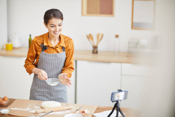 istock Beautiful Young Woman Filming Baking Video 1196741087