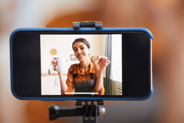 Smartphone Vlogging Close up of smartphone screen with smiling woman recording cooking tutorial for video channel, copy space influencer photos stock pictures, royalty-free photos & images