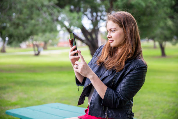 istock Russian Woman using smartphone in a park 1196743230