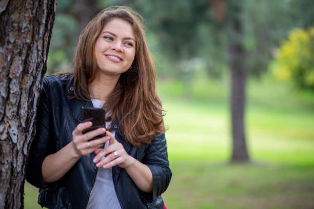 istock Russian Woman using smartphone in a park 1196744732