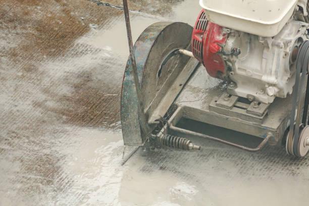 istock Worker using diamond saw blade machine cutting concrete road at construction site 1196746349