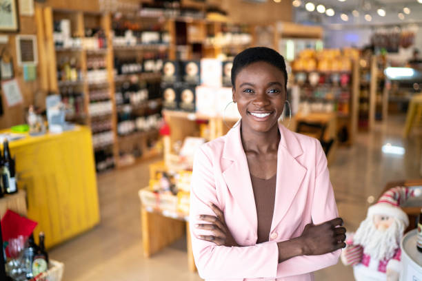 retrato de um proprietário feliz/mulher de negócios que está com os braços cruzados em uma loja - owner small business restaurant african ethnicity - fotografias e filmes do acervo