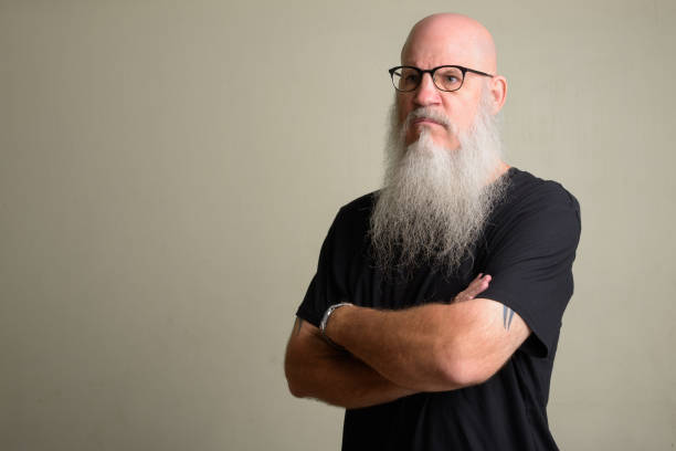 istock Angry mature bearded bald man thinking with arms crossed 1196751981