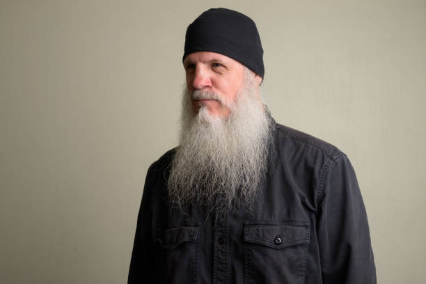 istock Mature man with long gray beard thinking and wearing beanie hat 1196751995