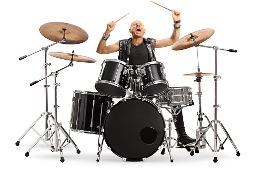 Male musician in leather vest playing a drum kit isolated on white background