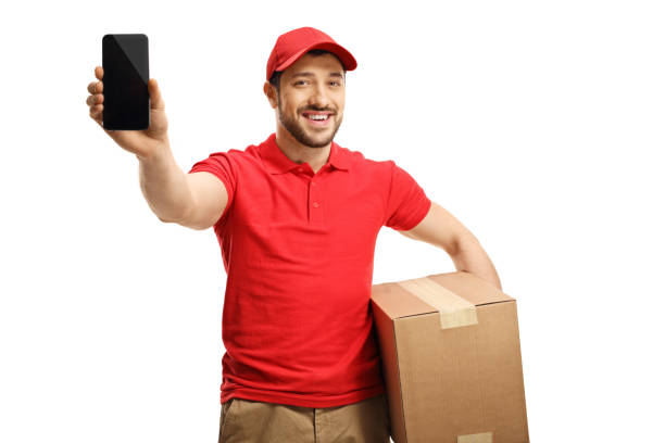 istock Smiling guy holding a package and showing a mobile phone 1196754171