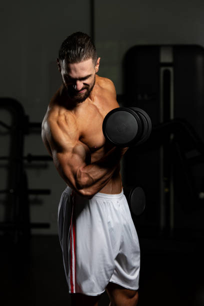 istock Biceps Exercise With Dumbbells In A Gym 1196754310