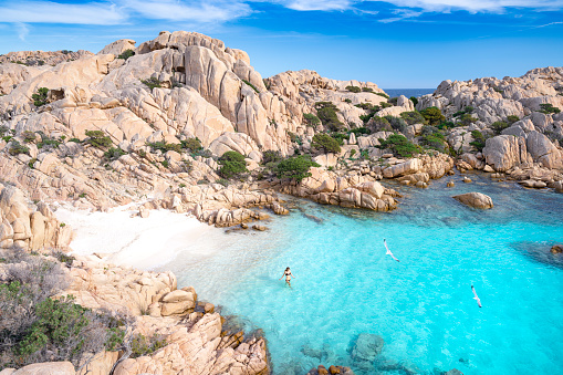 Beautiful woman going for a swim at a secluded Beach on Madallena, Sardinia, Italy. Nikon D850. Converted from RAW.