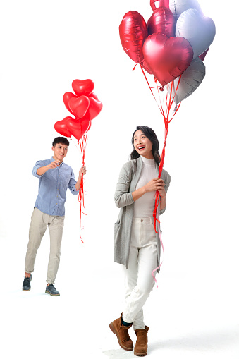 Romantic couples holding a heart-shaped balloons