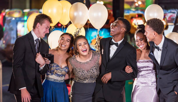 Group of multi-racial teenagers having fun at prom A multi-ethnic group of six teenagers, three multi-ethnic couples, having fun at their high school prom. The two girls are wearing prom dresses and their dates are wearing a suit and tuxedo. prom stock pictures, royalty-free photos & images