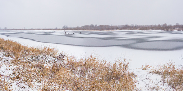 Oka River with fishermen on ice in winter