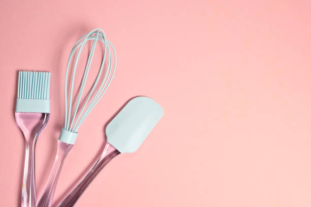 istock Blue silicone whisk, spatula and brush on light pink background with copy space  top view 1196771199