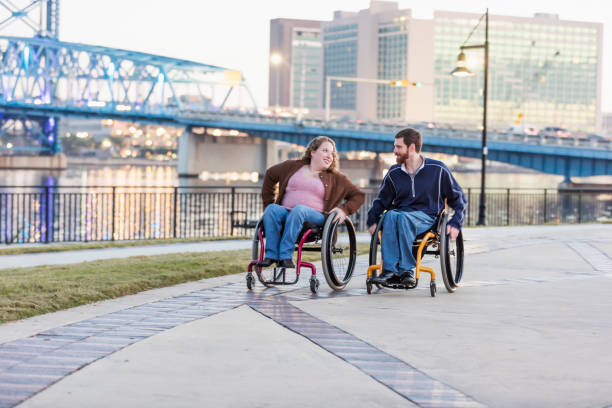 istock Couple in wheelchairs at city waterfront 1196771321