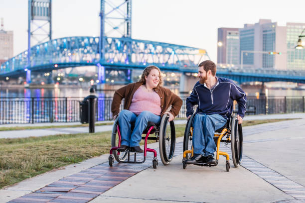 istock Couple in wheelchairs at city waterfront 1196771372