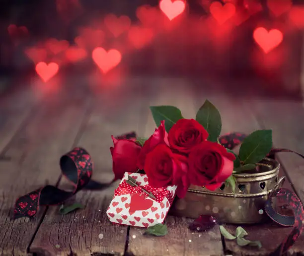 Photo of Valentine's Day Gift with Red Roses on a Dark Wood Background