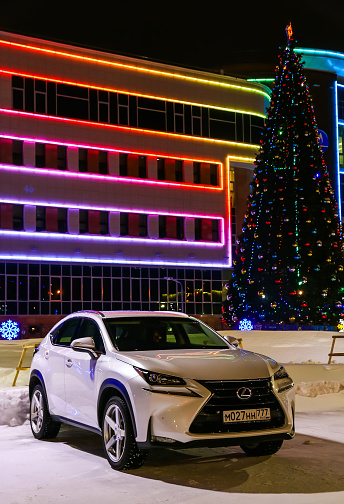 Novyy Urengoy, Russia - January 2, 2018: White crossover Lexus NX at the background of a Christmas tree.