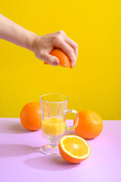 istock Female hand holding crushes orange and juice. 1196781198