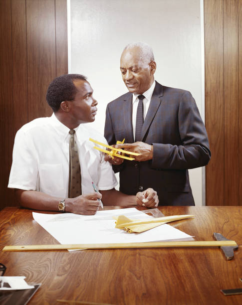 Two businessmen with model aeroplane by table   1968 stock pictures, royalty-free photos & images