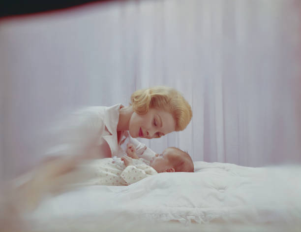 mãe olhando no seu bebê menino no quarto - 1955 - fotografias e filmes do acervo