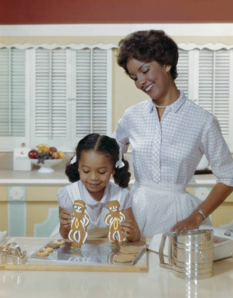 mãe e filha com biscoitos de gengibre sorridente - pastry cutter family holiday child imagens e fotografias de stock