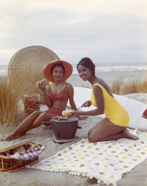 Young women holding hot dog on beach, smiling  barbecue grill photos stock pictures, royalty-free photos & images