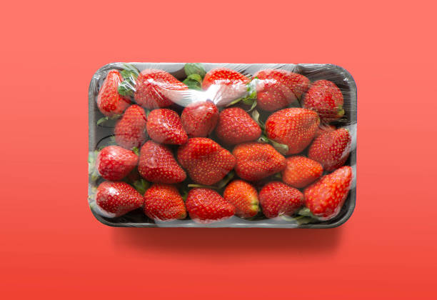 Strawberries in plastic box on a slate board, top view