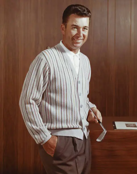 Photo of Man holding golf club, smiling