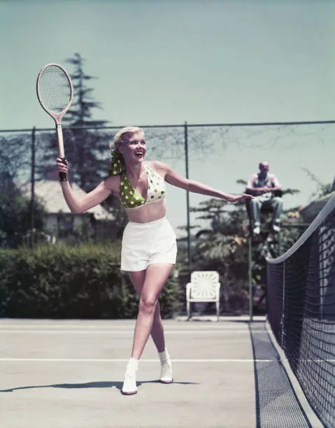 Photo of Young woman playing tennis, smiling