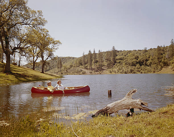 Couple fishing from canoe in lake   canoe photos stock pictures, royalty-free photos & images